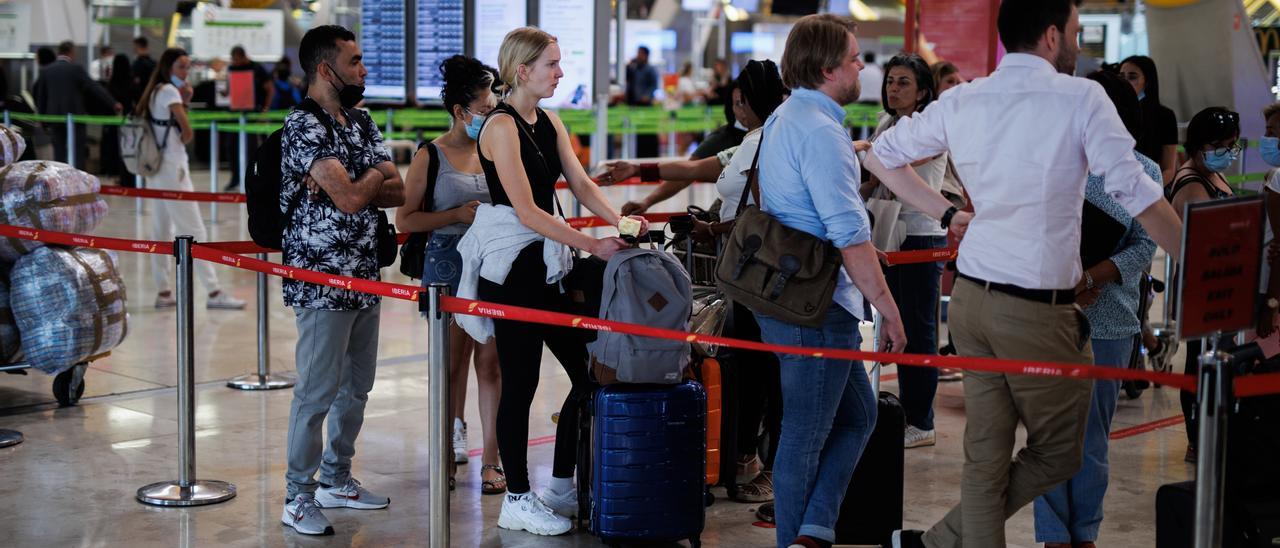 Varias personas con maletas hacen cola en la T4 del aeropuerto Adolfo Suárez Madrid-Barajas.