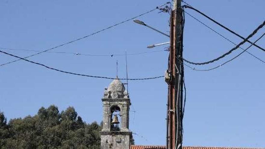 Una de las luminarias, con la iglesia románica al fondo. // S.A.