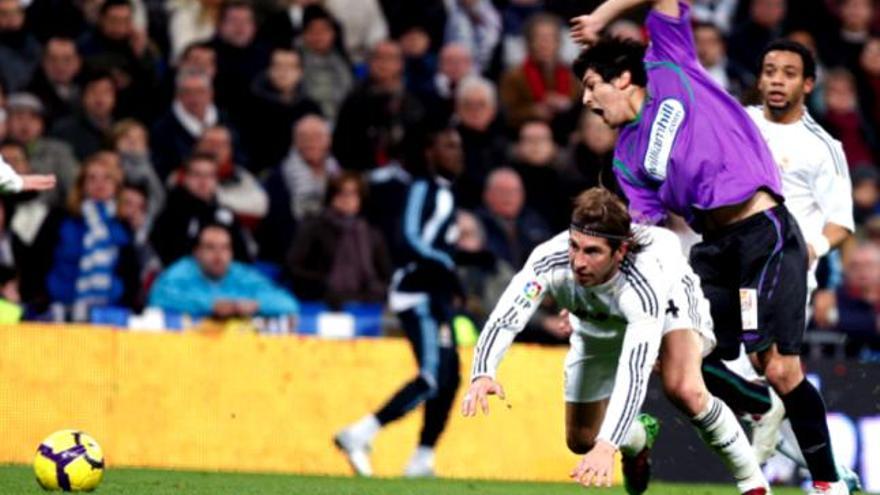 El defensa del Real Madrid Sergio Ramos cae al suelo ante la entrada del centrocampista italiano Fernando Forestieri en el partido que el Málaga disputó en el Santiago Bernabéu.