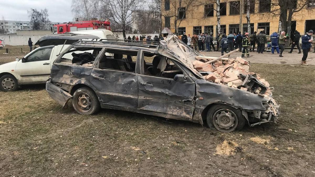 Un cotxe cremat davant d'un edifici militar bombardejat a Okhtyrka, a la regió de Sumy