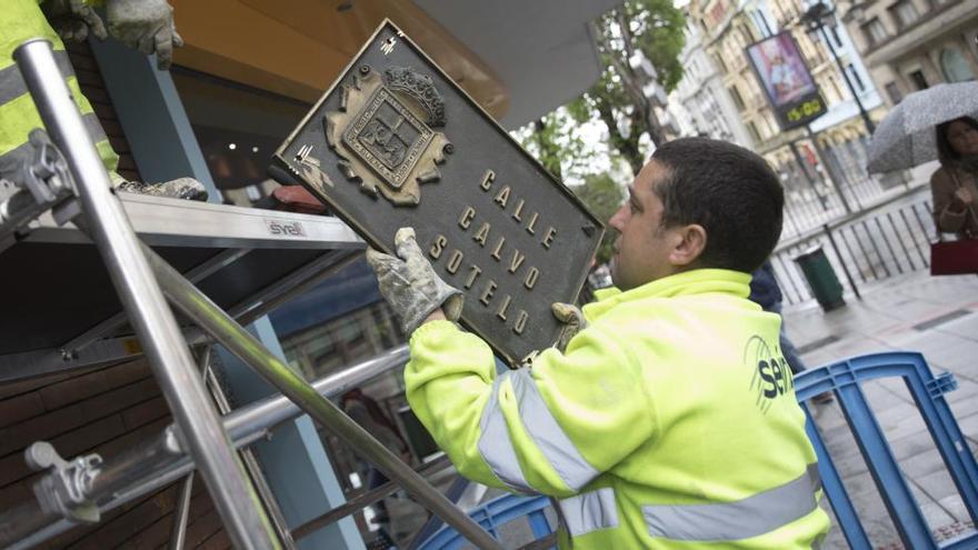 Un operario retirando la placa de la antigua calle Calvo Sotelo, ahora Federico García Lorca.