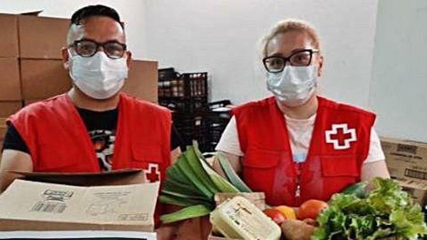 Dos voluntarios de Cruz Roja con las cajas de verduras.