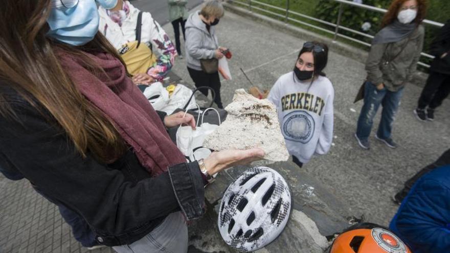 Una vecina del Barrio de las Flores sostiene un cascote caído de una de las fachadas. |  // CASTELEIRO/ROLLER AGENCIA