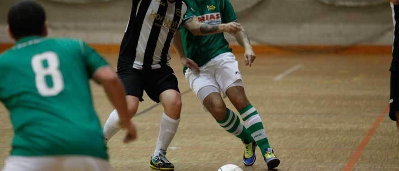 Un jugador de El Mallu trata de hacerse con la pelota ante la presión de un rival.