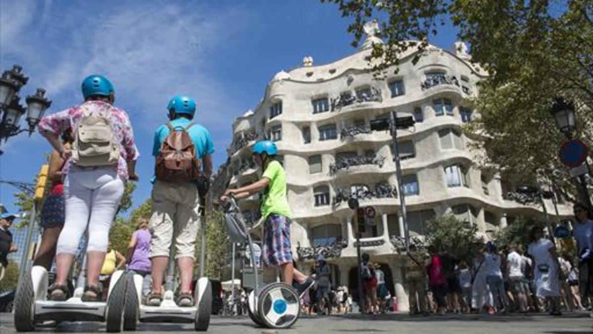 Turistas sobre 'segways' frente a La Pedrera, en Barcelona.