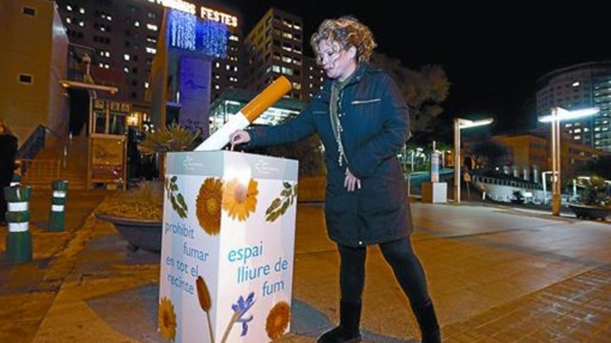 Una mujer apaga un cigarrillo en uno de los puntos habilitados por el Hospital Vall d'Hebron, junto a la Ronda de Dalt de Barcelona, ayer.