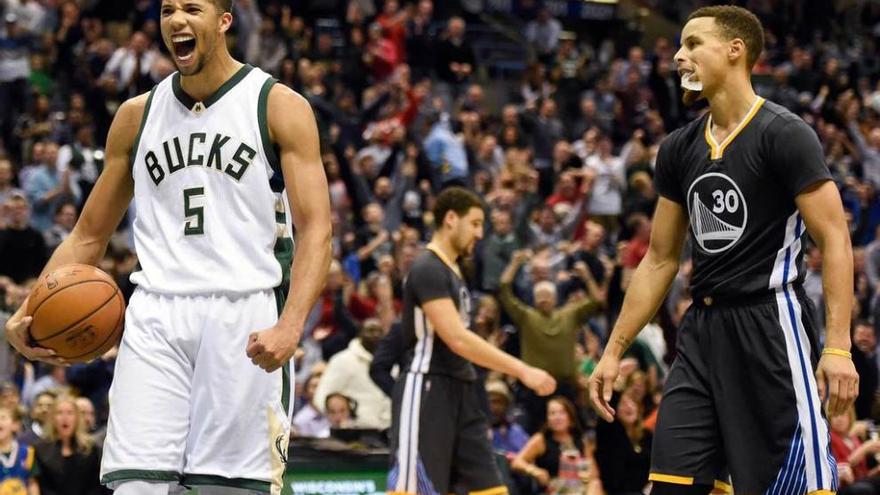 Carter-Williams celebra una canasta de los Bucks, con Stephen Curry a la derecha.