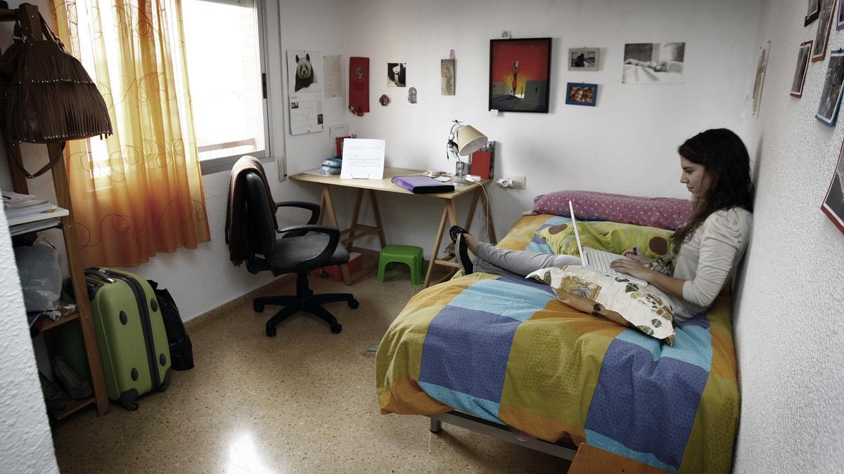 Una joven estudiando en su habitación.