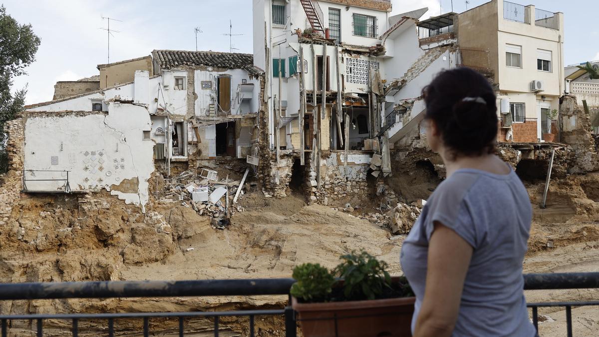 Una mujer mira las viviendas destrozadas por la riada, en Chiva.
