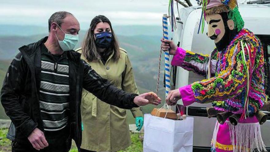 Un boteiro y la alcaldesa entregan a un vecino su ración de cabrito.  | // B.L.