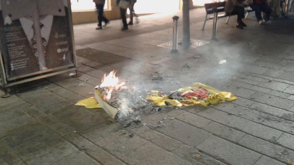 Quema de una bandera española este martes, Día de la Constitución, en el centro de Mataró. Un grupo de jóvenes la sustrajo de una parada instalada por la agrupación local de Ciutadans en el centro de la ciudad.