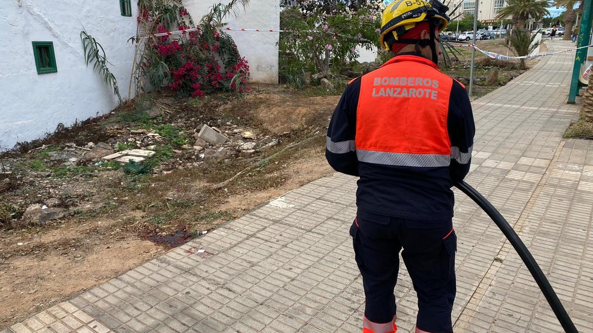 Un bombero del Consorcio de Emergencias de Lanzarote limpia los restos de sangre en la zona donde falleció apuñalado un joven en la Rambla Medular de Arrecife.