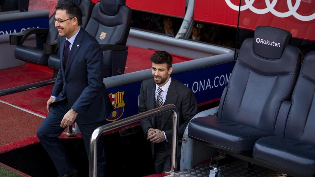 Piqué se asoma al Camp Nou junto a Bartomeu en la renovación que firmó en el 2018.
