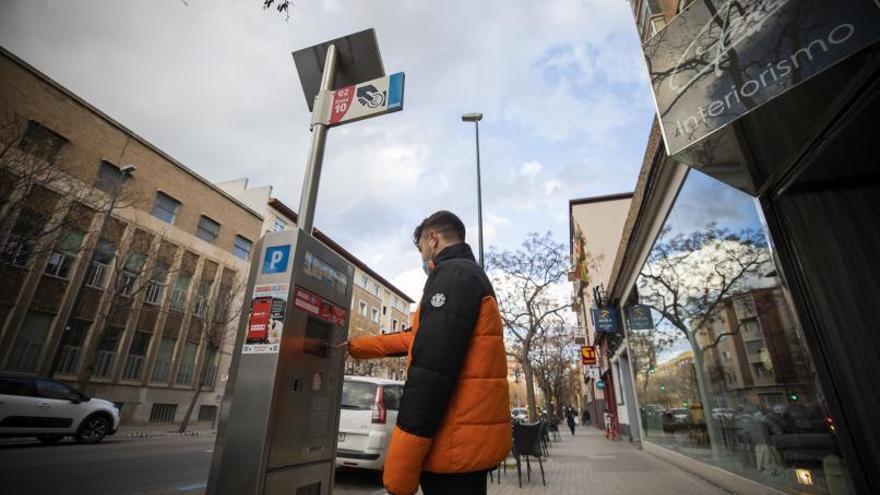 Un joven en una de las máquinas del estacionamiento regulado en una calle de la capital aragonesa.  | X