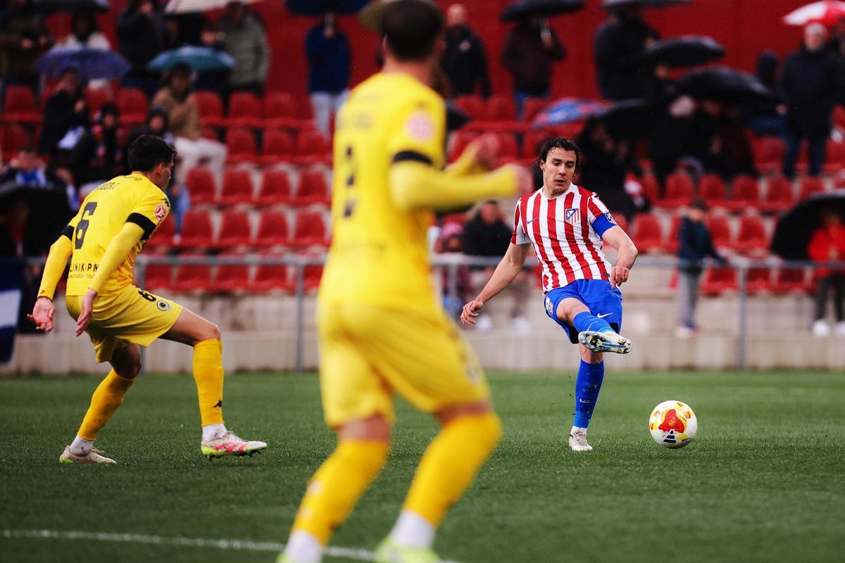 Javi Serrano, del Atlético Madrileño, golpea el balón con Roger Colomina, a la izquierda, defendiéndole.