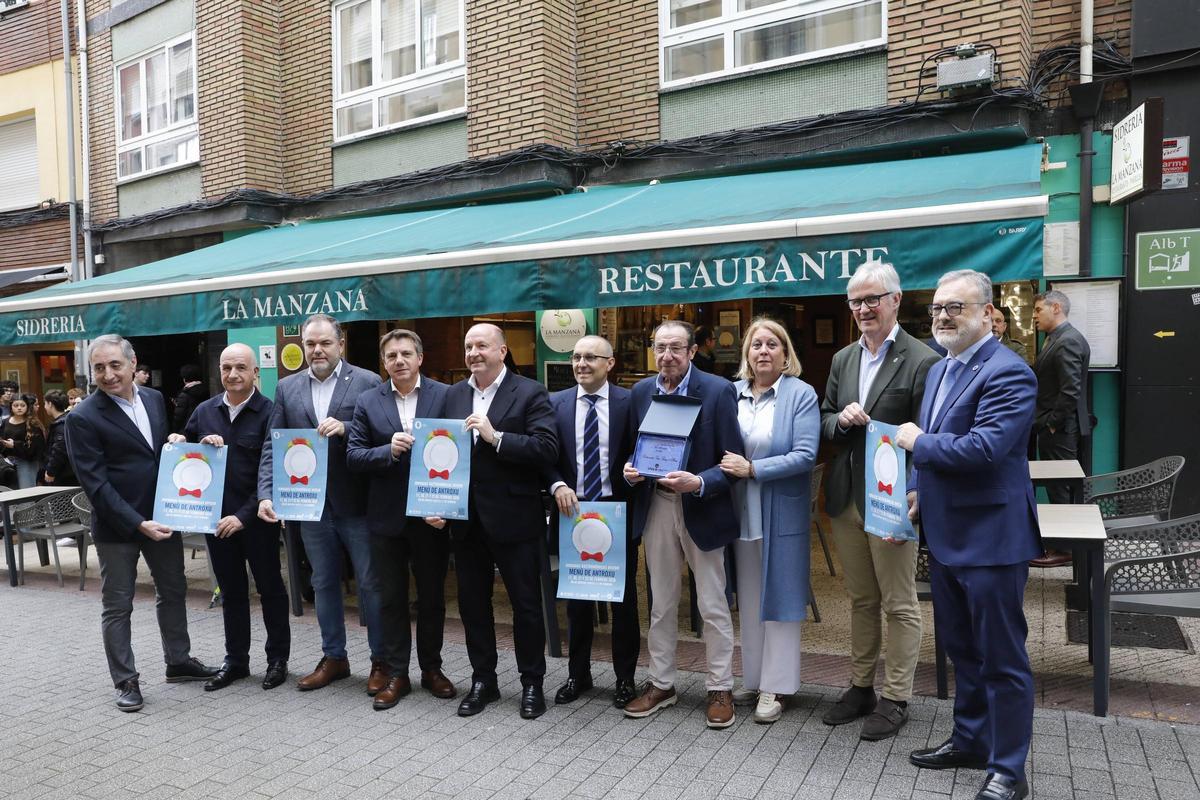 Por la izquierda, Luis Alberto Martínez, Rubén Castro, Carlos Paniceres, José Luis Álvarez Almeida, Javier Martínez, Fernando Corral, Julio Fernández Riera, Ana Guzmán, Marcos Niño y Alfredo García Quintana con los carteles del menú de Antroxu de este año.