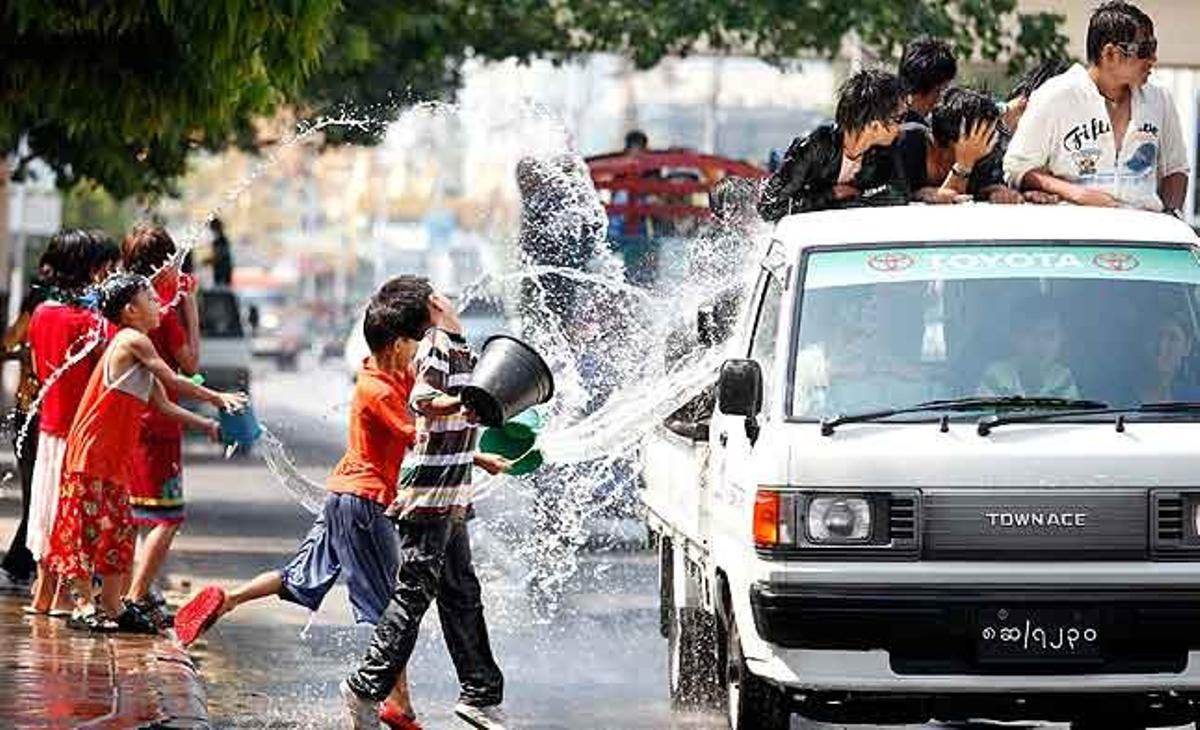Nens tiren aigua a un vehicle celebrant Thingyan, el festival de l’aigua del nou any birmà, a Rangun (Birmània).