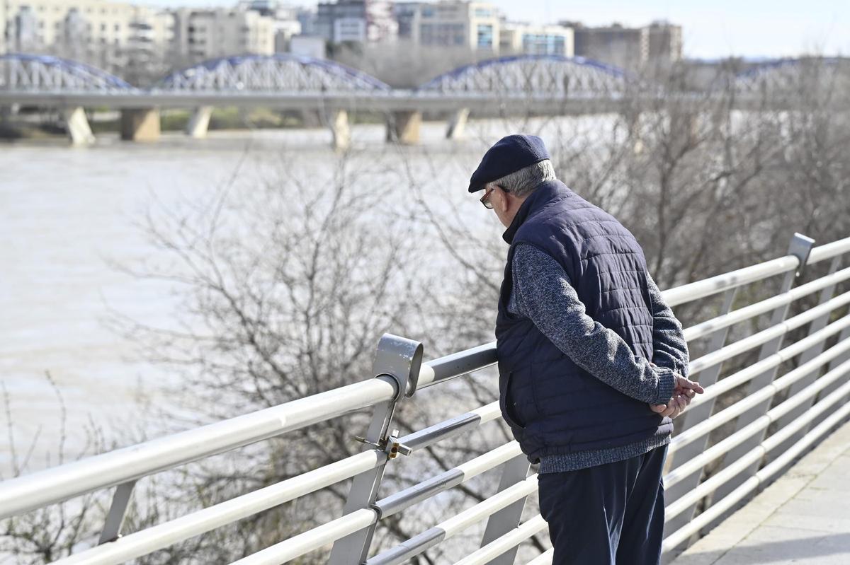 Un hombre observa el caudal del Ebro, este domingo en Zaragoza.
