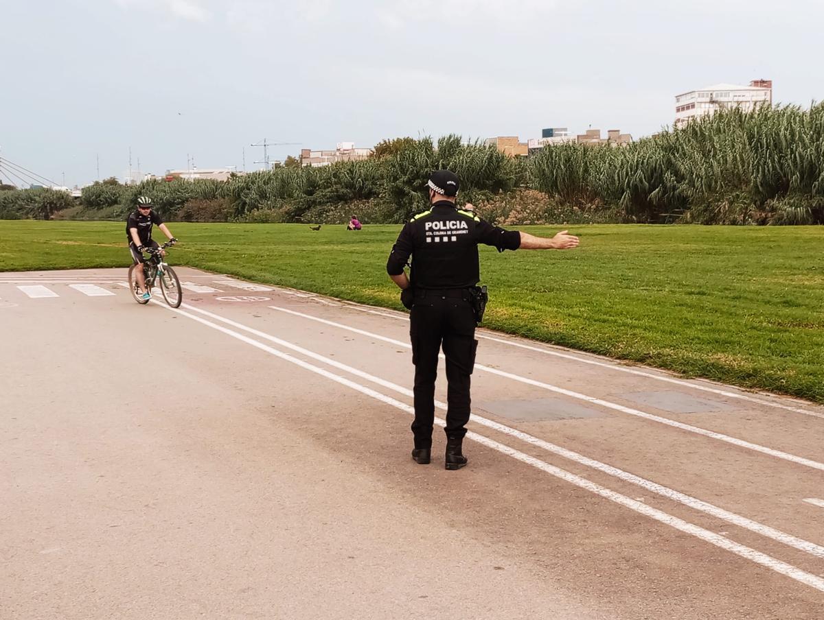 Un agente de policía local y un ciclista en el Parc Fluvial del Besòs