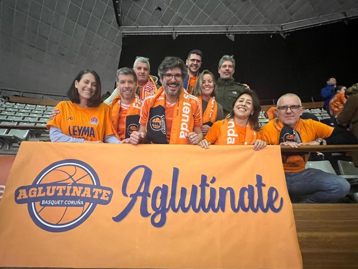 La agrupación Aglutínate posa con su pancarta en el Coliseum