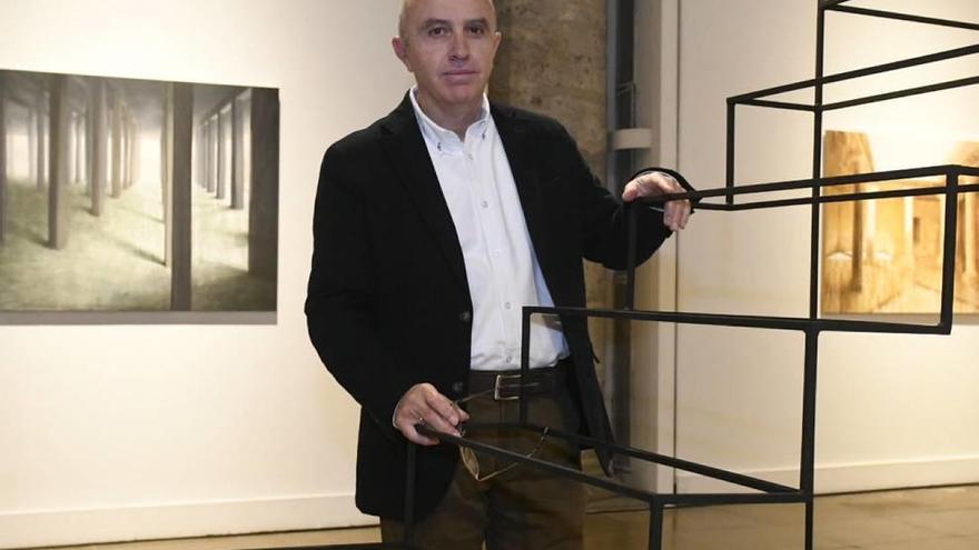 El artista Esteban Bernal posa en el Almudí con algunas de las obras de la exposición.