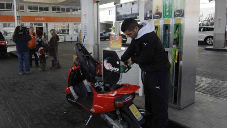 Un motociclista reposta en una gasolinera.