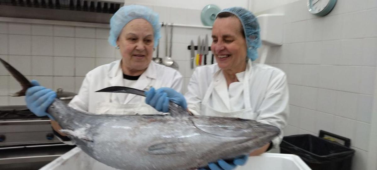 Las voluntarias Ana Gutiérrez Álvarez y Flori Fernández García, con el bonito en el comedor solidario de Mieres.