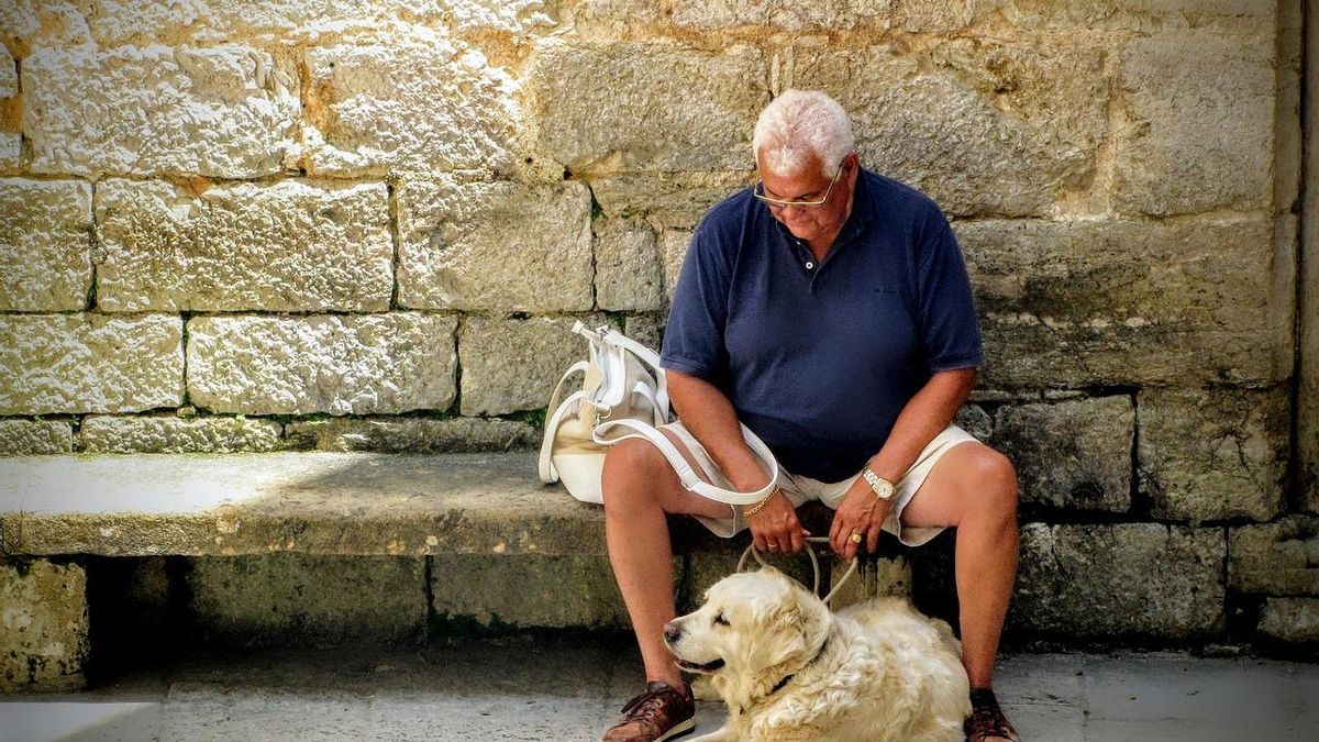Un jubilado sentado junto a su perro