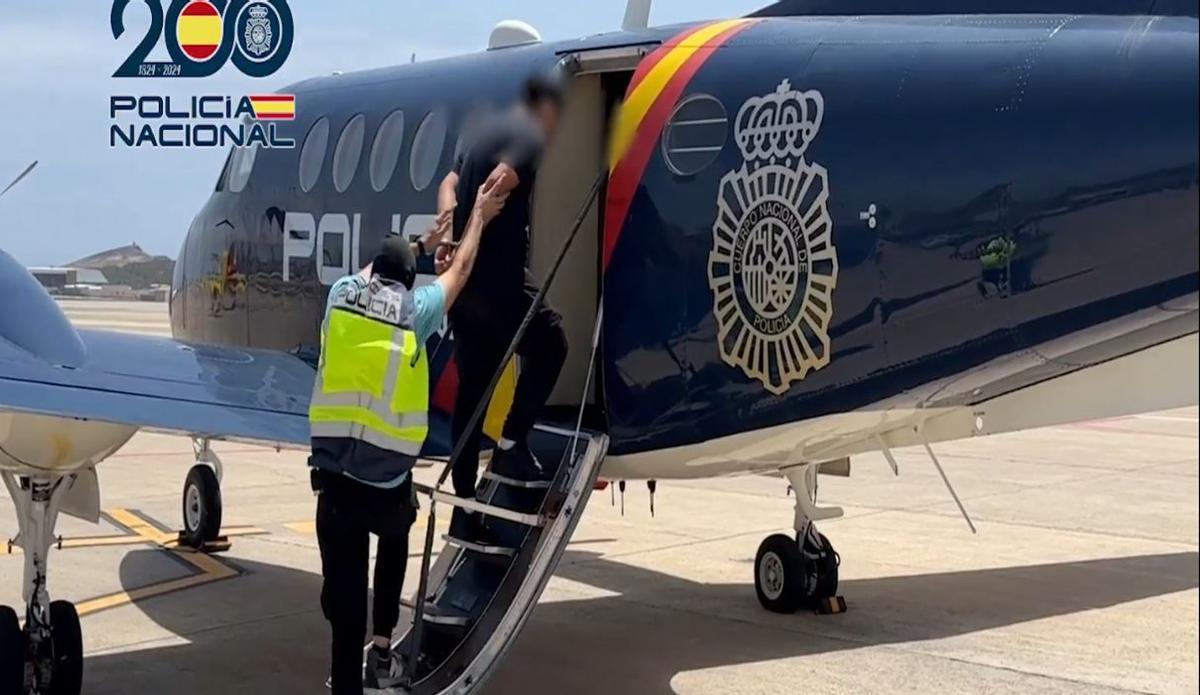 El momento del traslado de uno de los hackers en el avión oficial a Madrid para declarar ante la Audiencia Nacional.