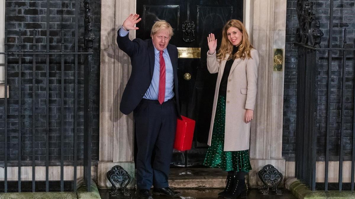 El primer ministro británico, Boris johnson, y su novia, Carrie Symonds, frente a la puerta de la residencia oficial.