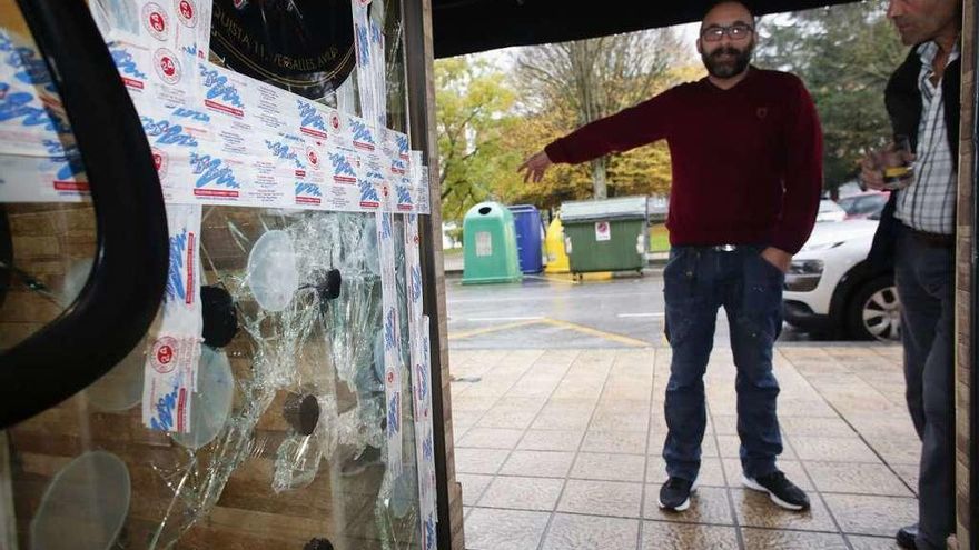 Por la izquierda, José Antonio Rodríguez y su vecino Javier Millán, ayer, ante la puerta rota.