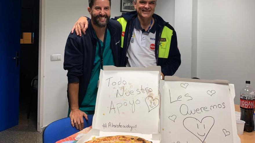 Dos trabajadores sanitarios de Urgencias reciben pizzas con mensajes de ánimo de la iniciativa #Ahoratecuidoyo.