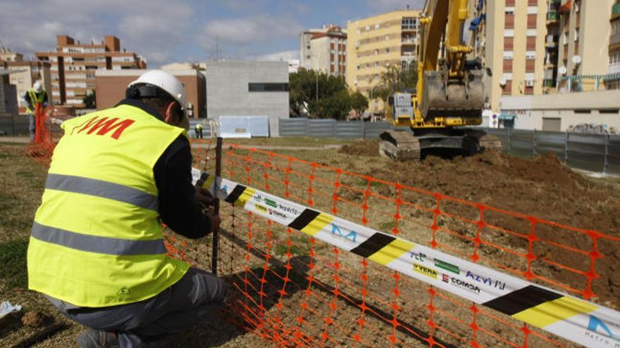 Un trabajador despliega una valla protectora en la zona de las obras recién iniciadas.