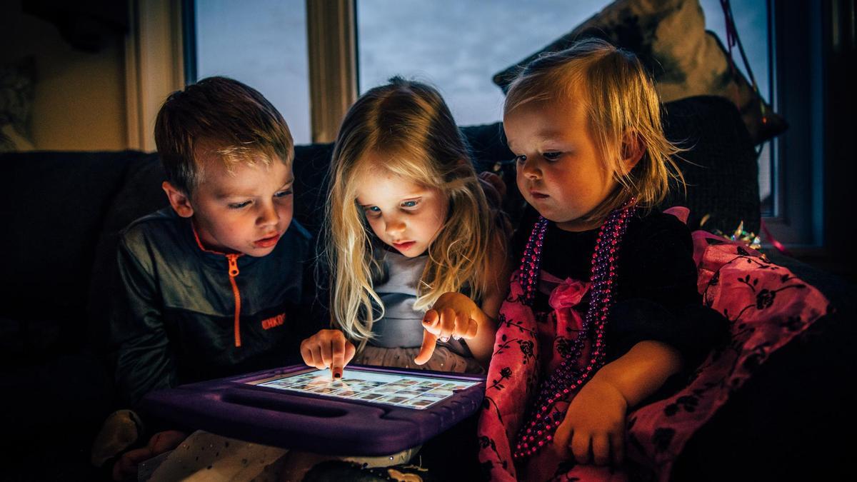 Tres niños pequeños con una tableta.