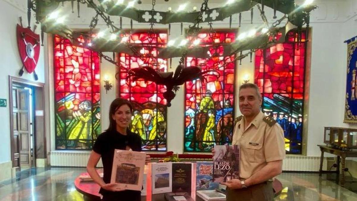 La concejala Lourdes García recibe los libros donados de manos del Delegado de Defensa, el coronel Jesús Moreno.