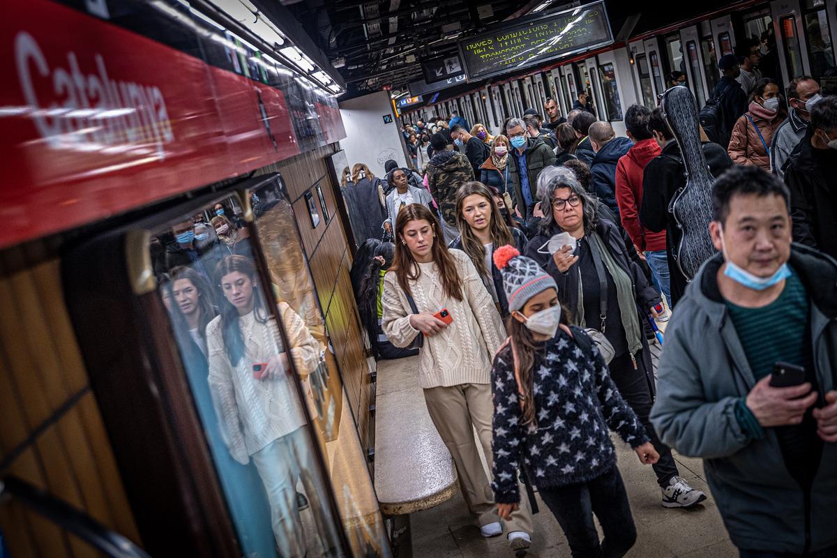 Viajeros de metro en el andén de la línea 1 de la estación de Catalunya, en Barcelona.