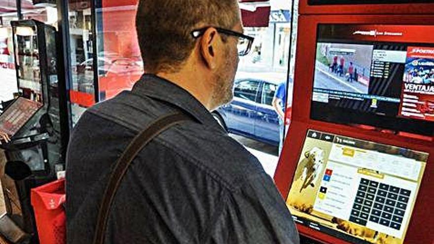 Un hombre juega en una máquina de apuestas deportivas