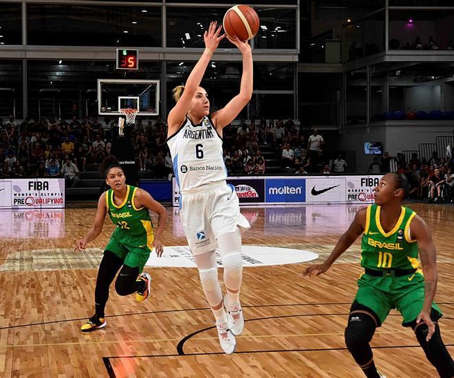 Victoria LLorente prueba en la canasta mientras intenta un bloqueo la alera Tati Pacheco del combinado del Brasil este domingo, en un juego del Preolímpico Femenino de Baloncesto en Bahía Blanca (Argentina).