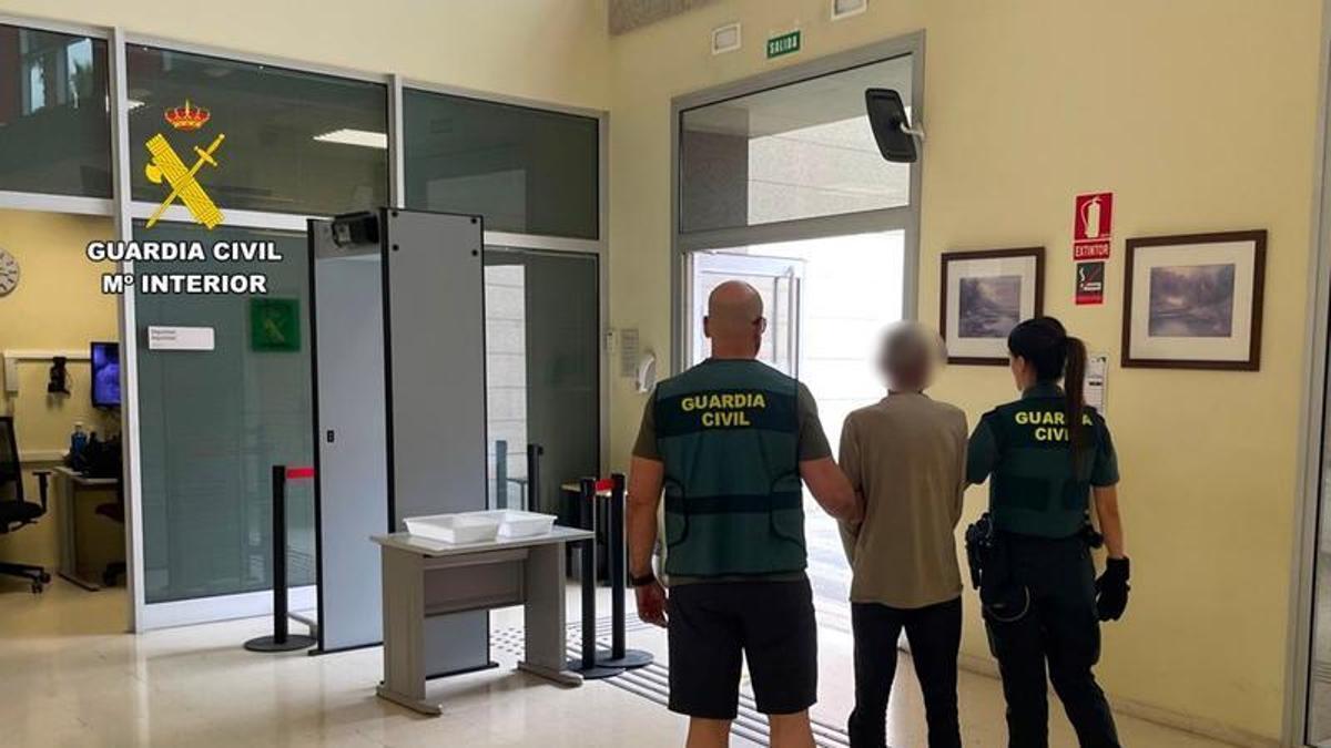 El detenido, acompañado por dos agentes de la Guardia Civil.