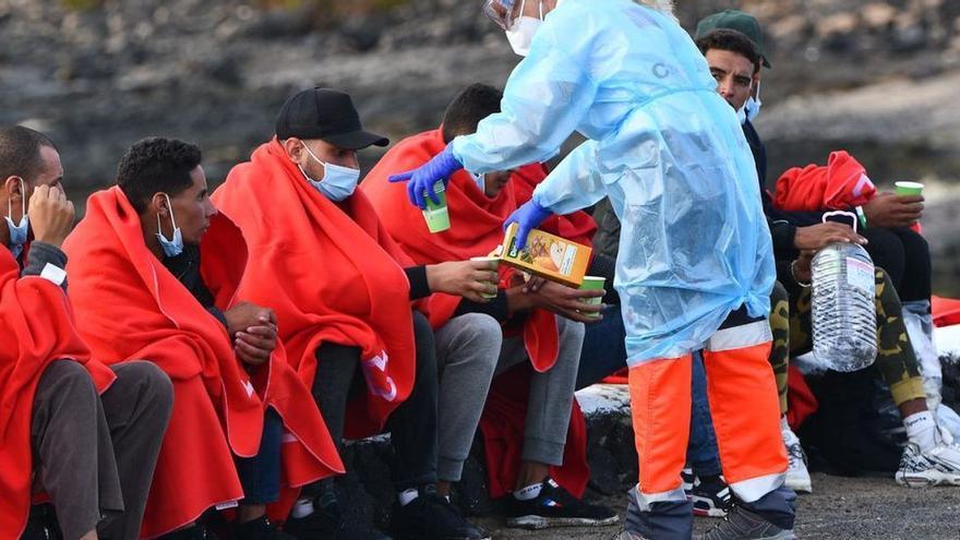 Una voluntaria de la Cruz Roja atiende a un grupo de migrantes en la zona de Las Caletas, en Teguise (Lanzarote).