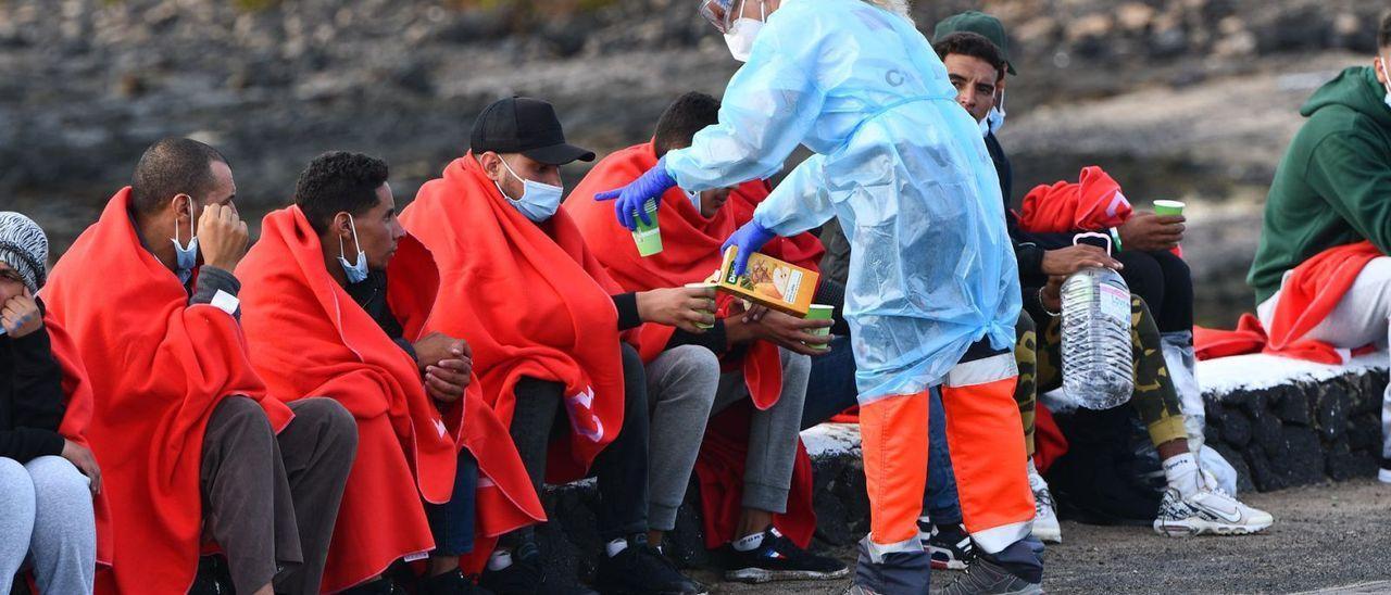 Una voluntaria de la Cruz Roja atiende a un grupo de migrantes en la zona de Las Caletas, en Teguise (Lanzarote).