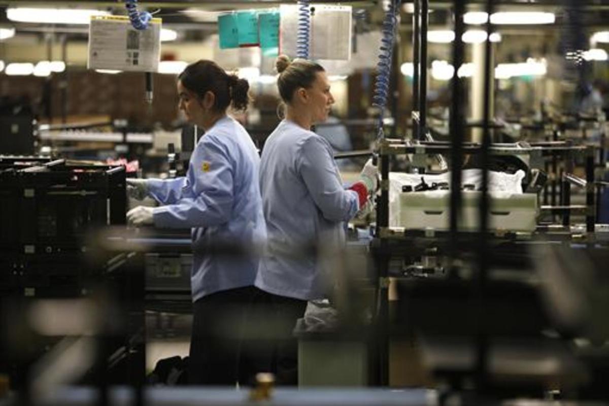 Dos trabajadoras durante su jornada laboral en la cadena de montaje de una empresa española.