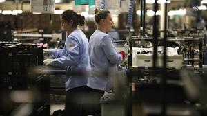 Dos trabajadoras durante su jornada laboral en la cadena de montaje de una empresa española.