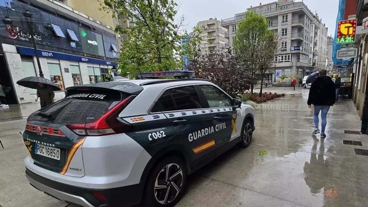 Un vehículo de la Guardia Civil custodiando un negocio en Vilagarcía, esta mañana.