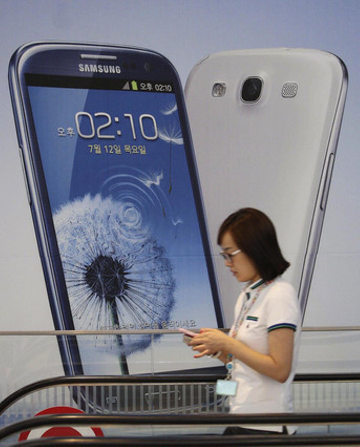 Una dona passa per davant d’un anunci d’un Galaxy III, a Seül. Una dona passa per davant d’un anunci d’un Galaxy III, a Seül.