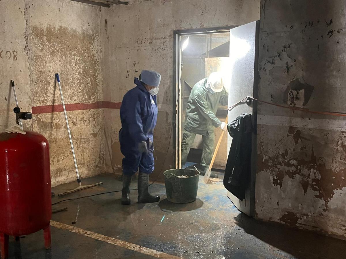 Trabajadores limpian el último garaje de Catarroja en el que está actuando la Diputación de Valencia.