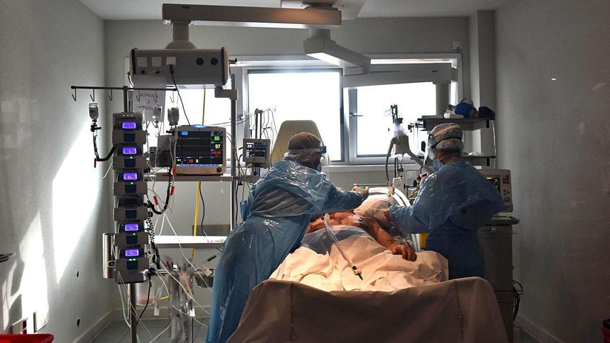 Dos sanitarios atienden a un paciente ingresado en la UCI del Reina Sofía de Murcia.