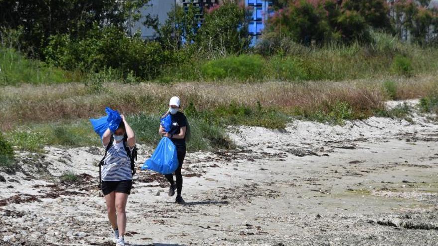 Los voluntarios trasladan los residuos desde la playa.