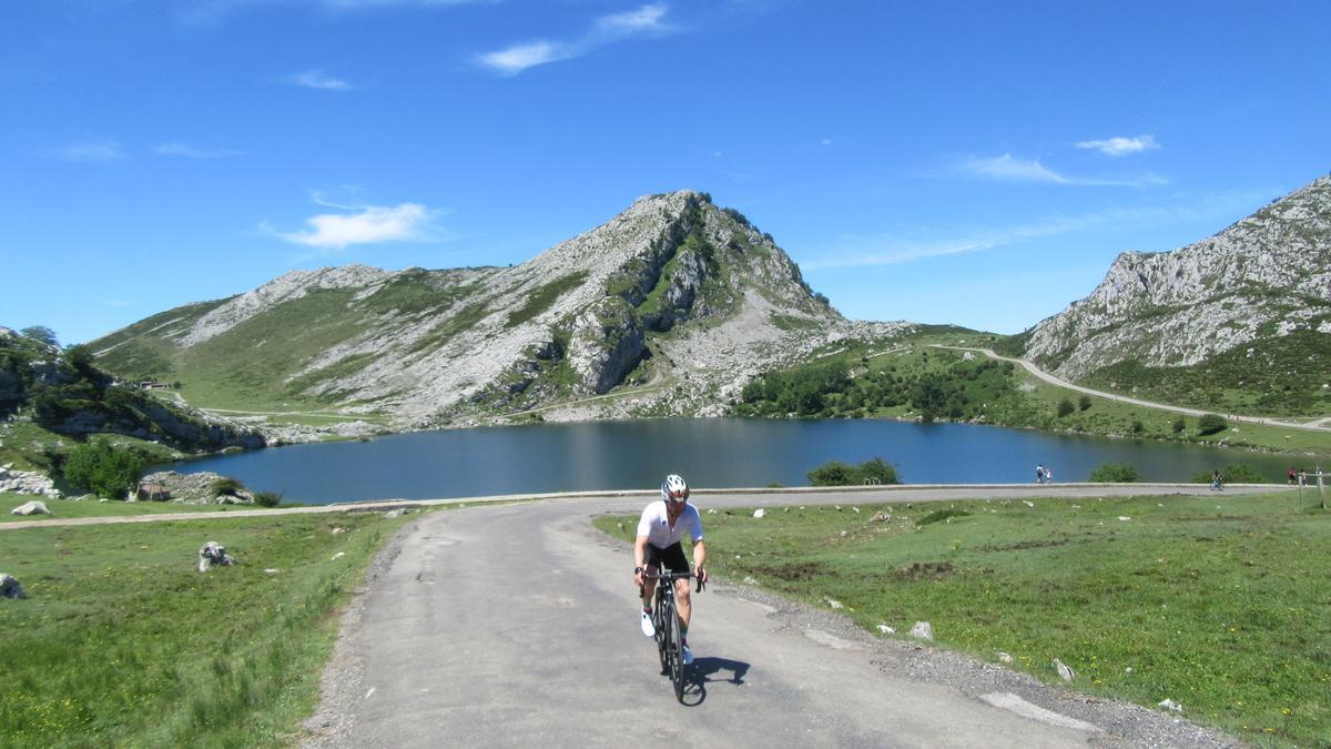 Un ciclista deja atrás el lago Enol, casi vacío de visitantes.