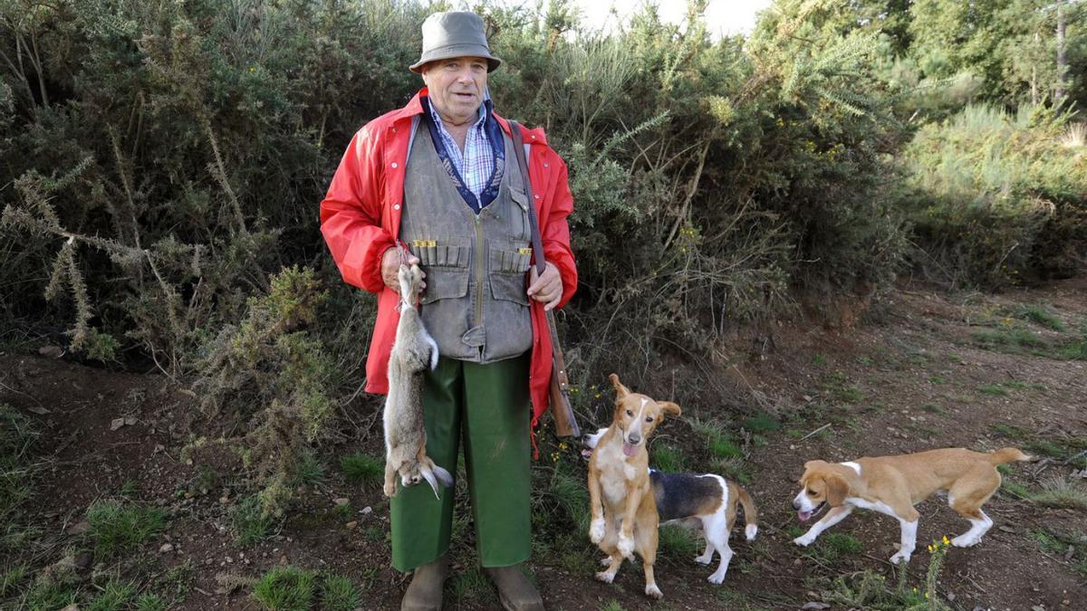 Un cazador, con su presa y los perros.